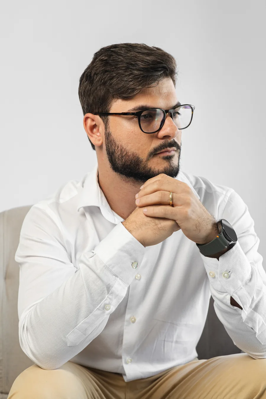 Guilherme Creimer sentado, de camisa branca, com as mãos apoiadas.